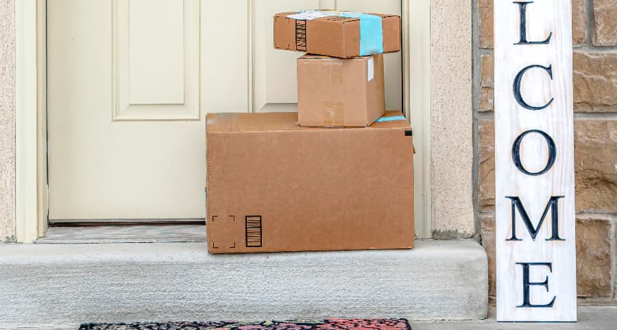 Packages on the doorstep of a home with a welcome sign in Jackson